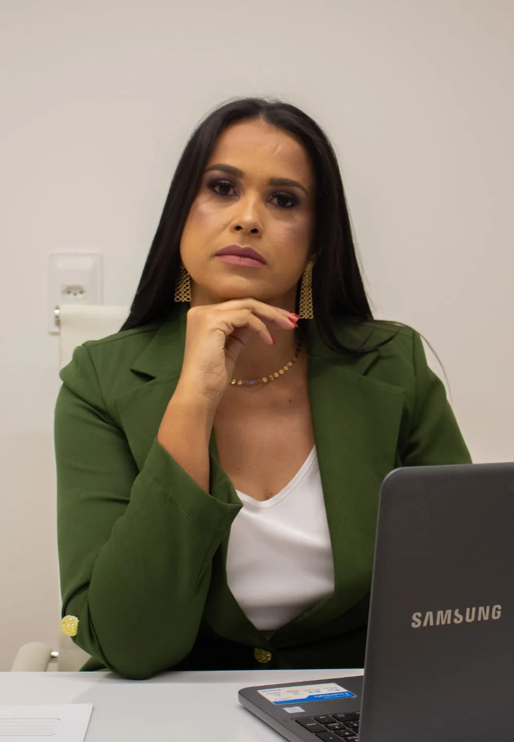 Dra. Liliane Reis, biomédica esteta, sentada à mesa do consultório