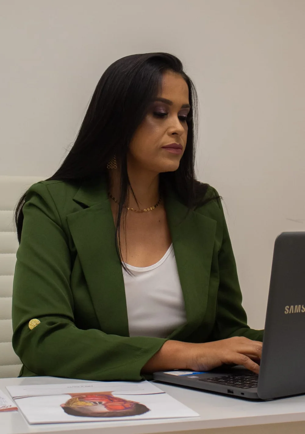 Dra. Liliane Reis estudando o caso de uma paciente com material de anatomia