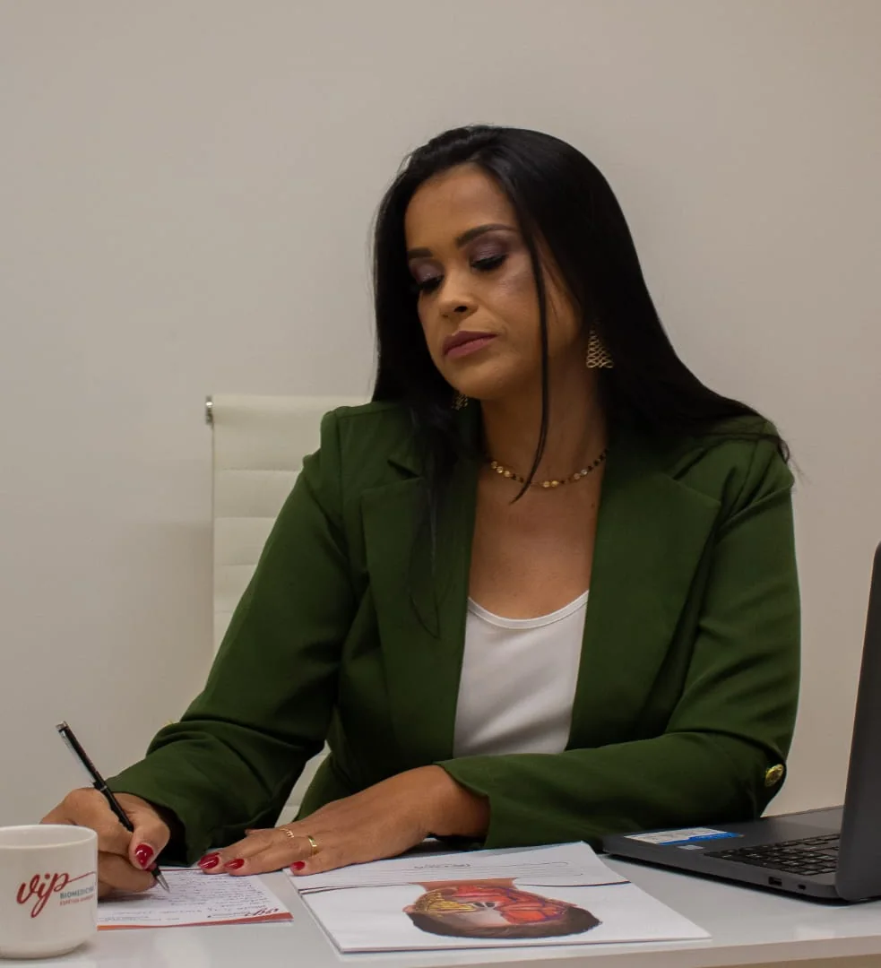 Dra. Liliane Reis escrevendo o plano de tratamento de uma paciente