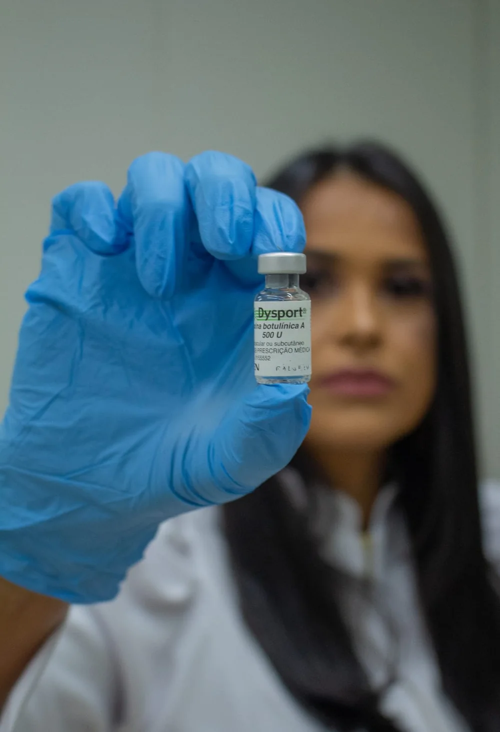 Dra. Liliane Reis segurando um frasco de toxina botulínica